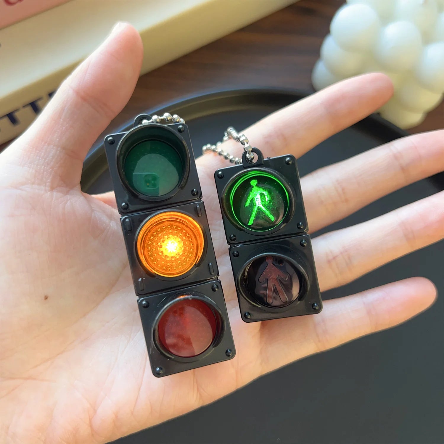 Child holding a miniature LED traffic light keychain for hands-on road safety learning.