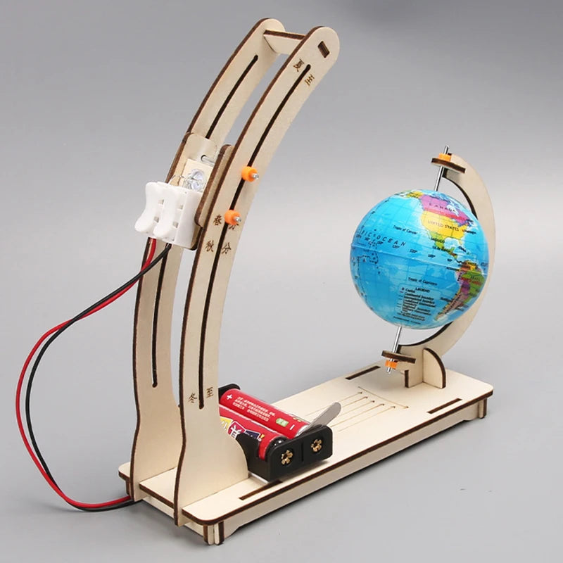 BrightOrbit day-night cycle model on a table with child pointing to illuminated hemisphere